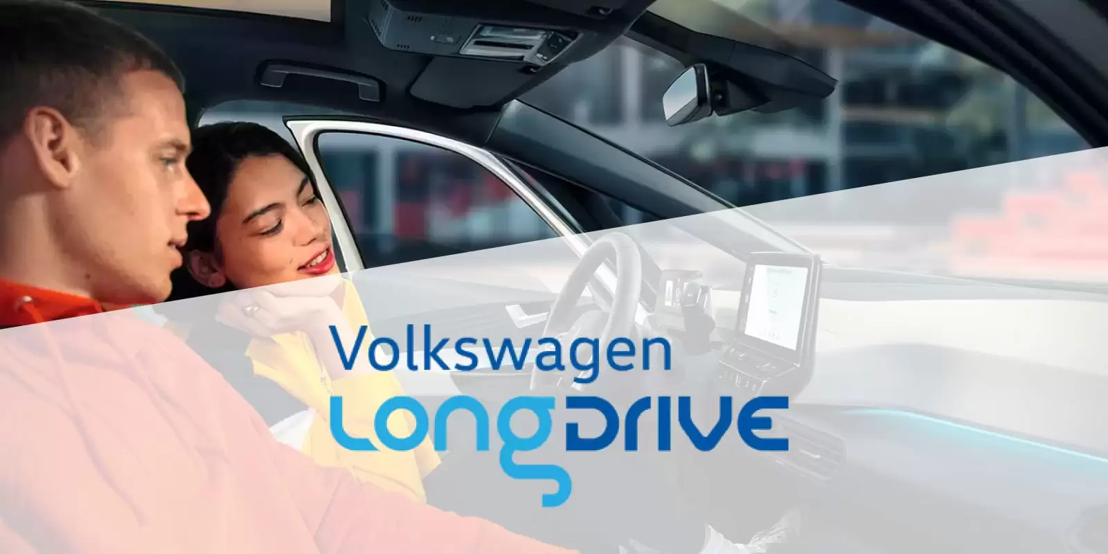 Una pareja dentro de un coche con el logo de Volkswagen Longdrive