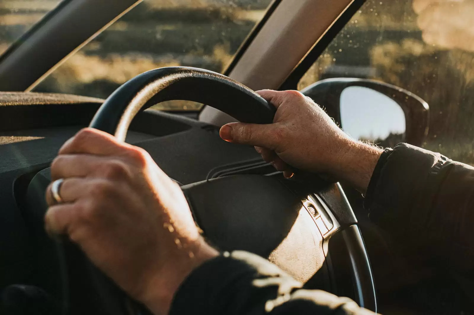 Detalle de manos al volante de un coche del Grupo Volkswagen con un plan de mantenimiento y desgaste Long Drive Service