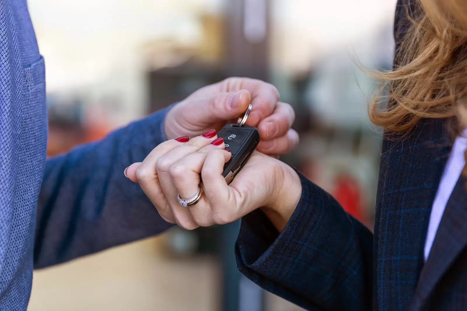 Primer plano de las manos de un hombre entregando la llave de un Volkswagen a una mujer