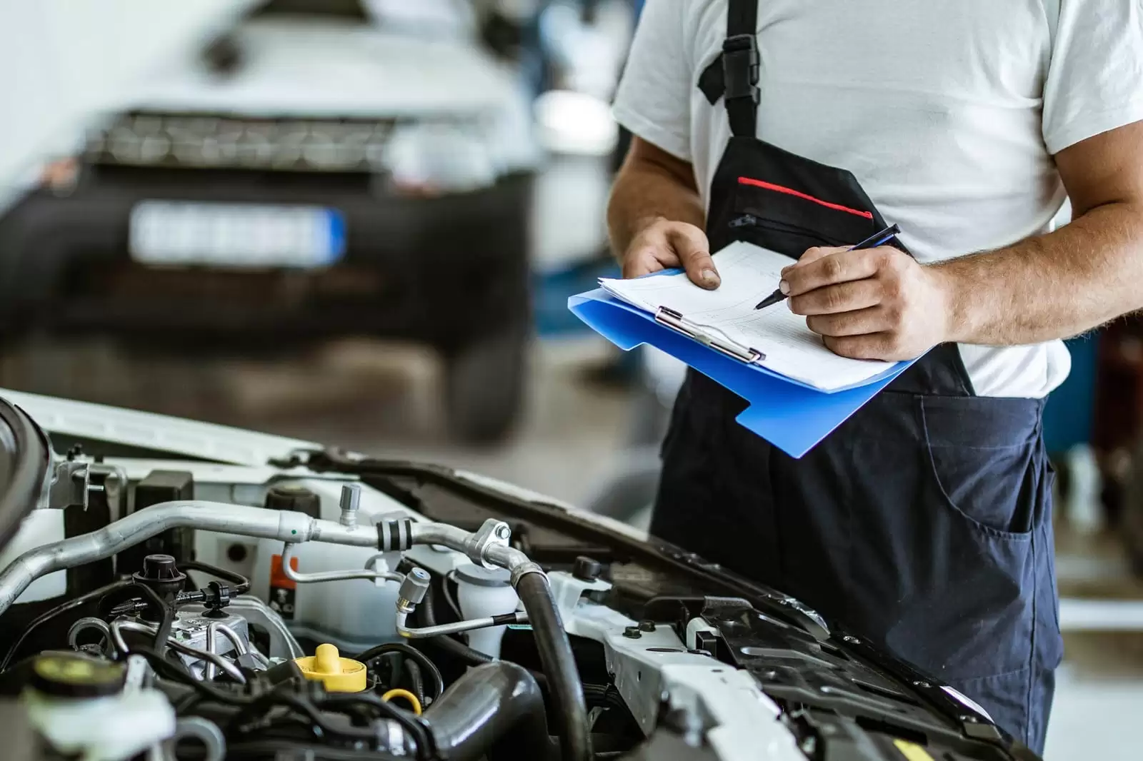Un mecánico toma notas sobre las revisiones y mantenimiento del coche en un taller oficial del Grupo Volkswagen