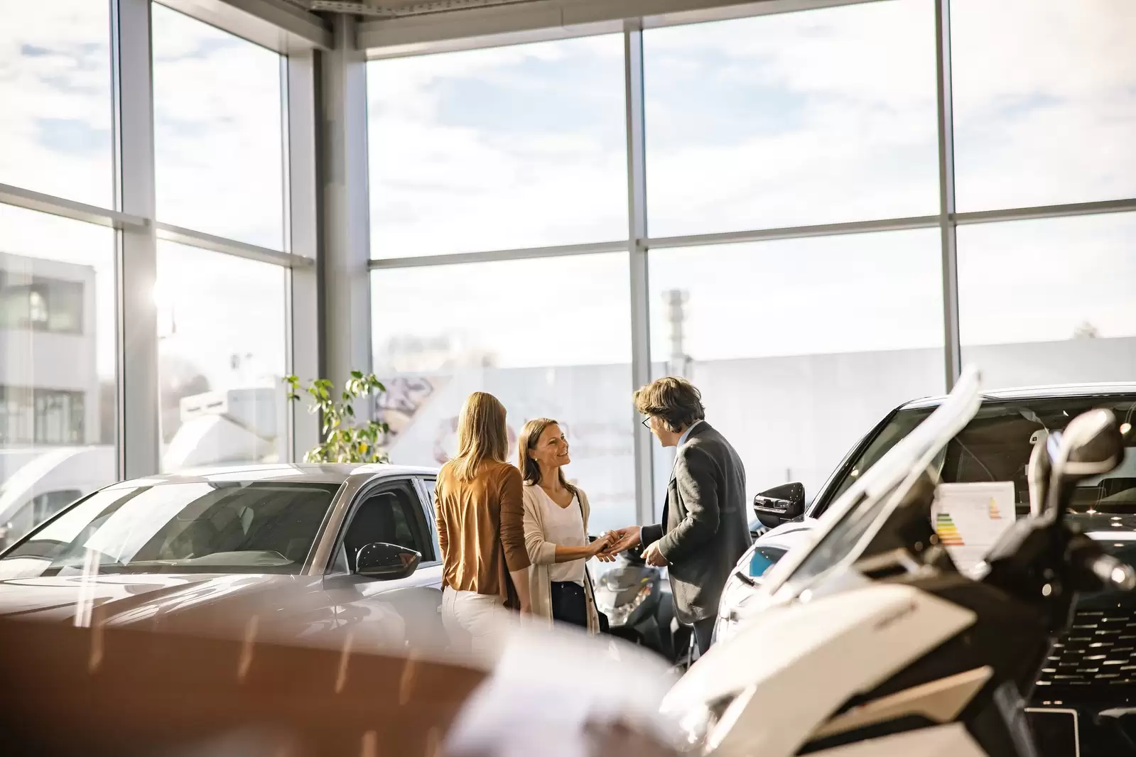 Una mujer habla con un asesor comercial que le muestra un coche de renting empresas en un concesionario del Grupo Volskwagen