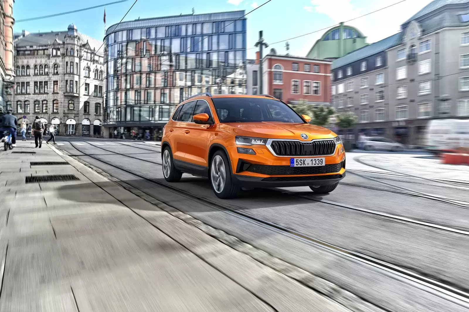 Vista frontal de un coche de Renting Škoda Karoq, color naranja, en la ciudad 